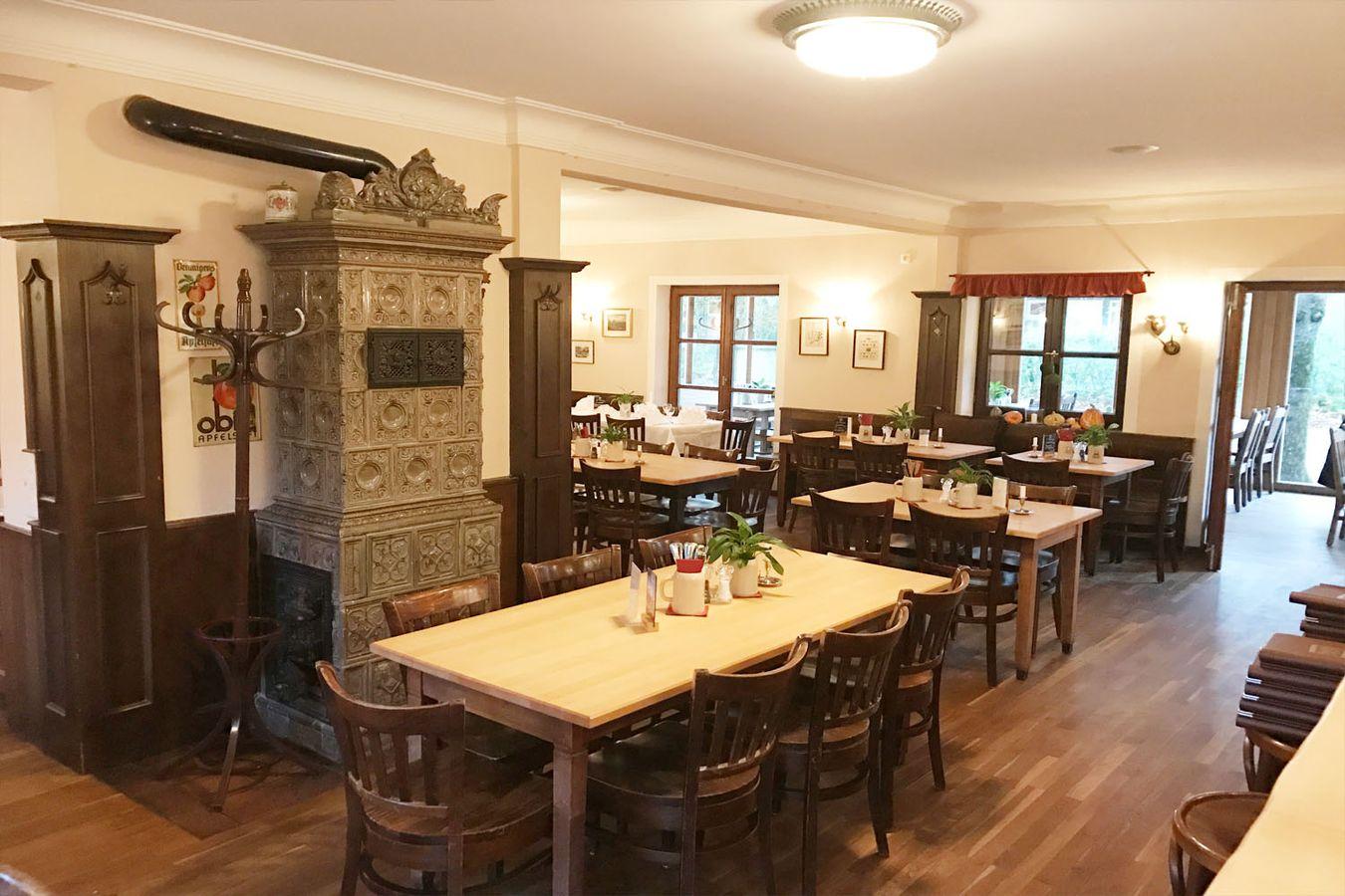 Gaststube im Wirtshaus Zamdorfer mit antikem Kachelofen und Holztischen